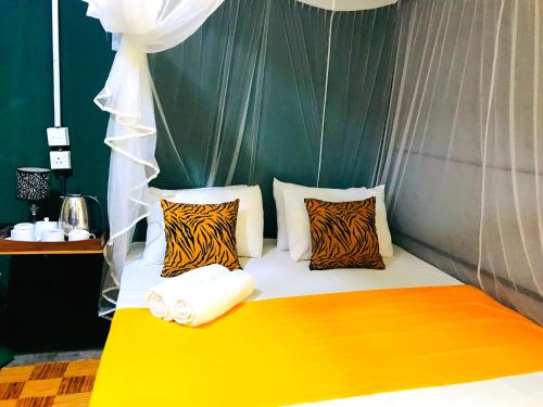 a bed with zebra pillows on top of it at Atha Safari Resort & Riverside Camping in Udawalawe