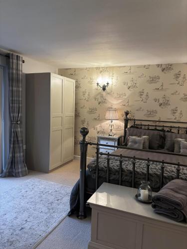 a bedroom with a bed with floral wallpaper at Luxury Farm Country Retreat in Chippenham
