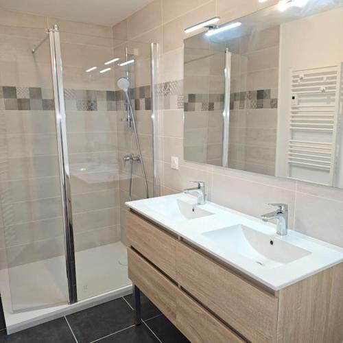 La salle de bains est pourvue d'une douche, de 2 lavabos et d'un miroir. dans l'établissement Maison néo bretonne rénovée à 2mn à pied d'une jolie plage, à Plouguerneau