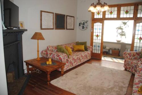 a living room with a couch and a table at Charming 3 bedroom house -No Loadshedding in Pretoria