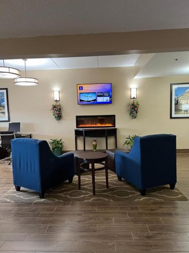 a lobby with two chairs and a table and a piano at Comfort Inn & Suites Wilkes Barre - Arena in Wilkes-Barre