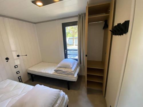 une petite chambre avec un lit et un placard dans l'établissement Cottage avec piscine à 300m de la plage, à Jullouville