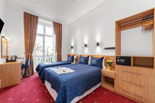a bedroom with a blue bed and a television at Jubilee Hotel Victoria in London