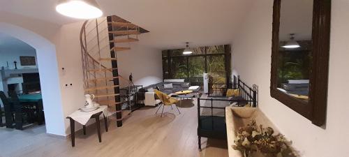 sala de estar con escalera de caracol, mesa y sillas en Gîte et Spa 21, en Savigny-le-Sec