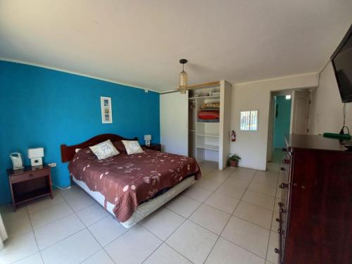 ein Schlafzimmer mit einem Bett und einer blauen Wand in der Unterkunft Casa de descanso Olmue in Olmué