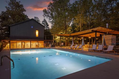 a swimming pool with chairs and a house at Roamstead Smoky Mountains in Cosby