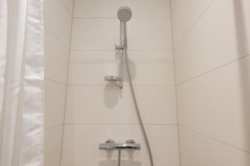 a shower with a shower head in a bathroom at Stunning 5 BR Flat by The Lakes in Copenhagen