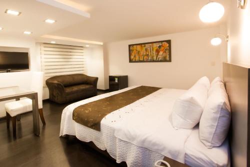 a hotel room with a bed and a chair at Hotel Torre del Bosque Pasto in Pasto