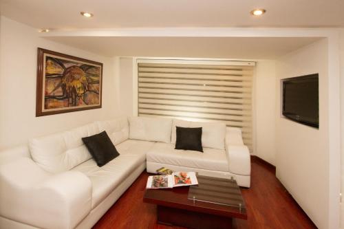 uma sala de estar com um sofá branco e uma mesa em Hotel Torre del Bosque Pasto em Pasto