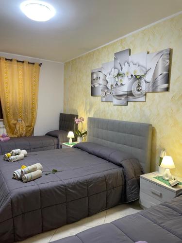 een slaapkamer met 2 bedden en schilderijen aan de muur bij B&B Bovianum in Boiano
