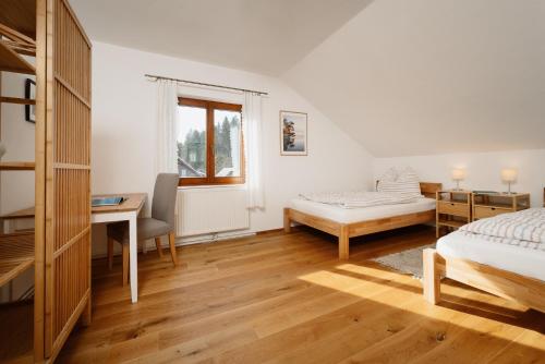 1 dormitorio con 1 cama, escritorio y 1 cama en Haus Grundlsee en Grundlsee