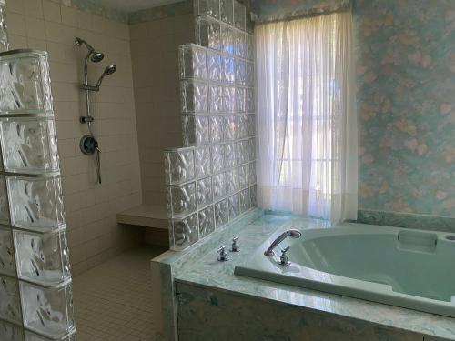 a bathroom with a bath tub and a window at Donkeytown at Turner Farms in Heltonville