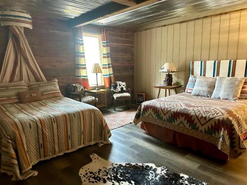 a bedroom with two beds and a chair in a room at Donkeytown at Turner Farms in Heltonville