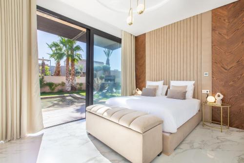 ein Schlafzimmer mit einem weißen Bett und einem großen Fenster in der Unterkunft Palais Rafi in Marrakesch