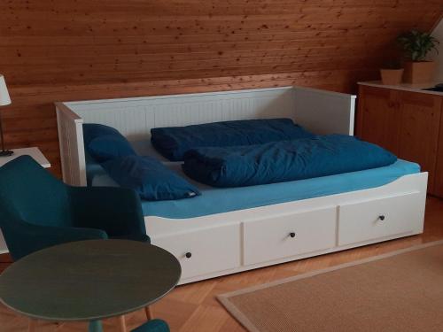 Bett mit blauen Kissen auf einem Zimmer in der Unterkunft Ferienwohnung Klute in Allendorf