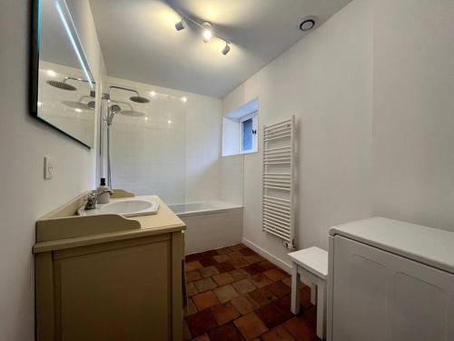 La Maison des Papillons - Nargis في Nargis: حمام أبيض مع حوض وحوض استحمام