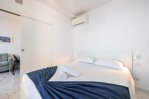 una camera da letto con un letto bianco con una coperta blu sopra di Sea view - 2 Bdr Promenade des Anglais a Nizza