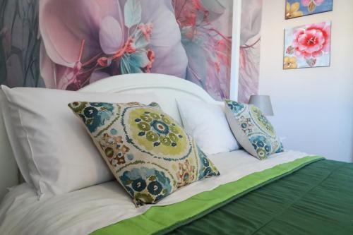 a bed with three pillows on top of it at Accademia Apartment in Sassari