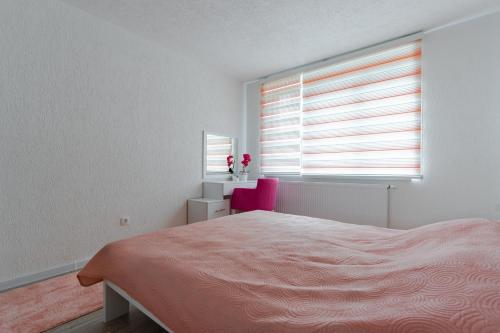 a white bedroom with a bed and a window at Mona Visoko in Visoko