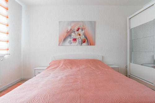 a white bedroom with a bed and a painting at Mona Visoko in Visoko