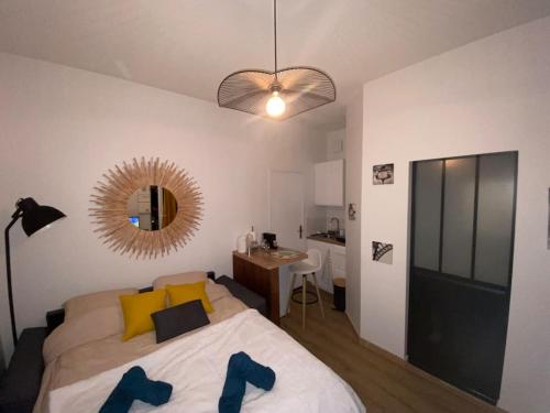 une chambre avec un lit, un miroir et un bureau dans l'établissement Le cosy studio du canal., à Montauban