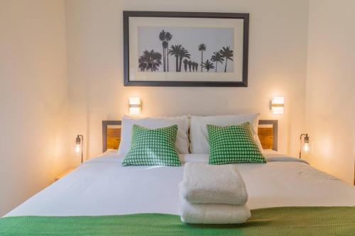 a bedroom with a bed with green and white pillows at 1-Bed Apt with rooftop pool Ocean Dr by the Beach in Miami Beach