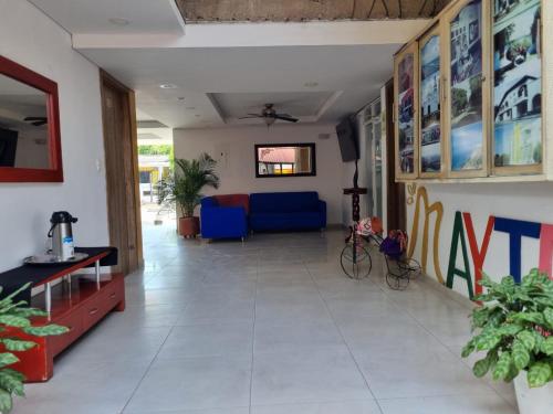 una sala de estar con sillas azules y rojas en una habitación en Hotel Mayte en Fonseca