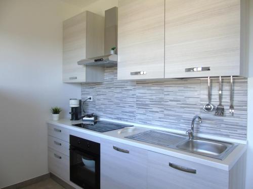 a kitchen with a sink and a stove at Homiday - WaterFront Montesilvano in Montesilvano