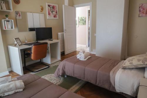 a bedroom with a bed and a desk with a computer at Accademia Apartment in Sassari