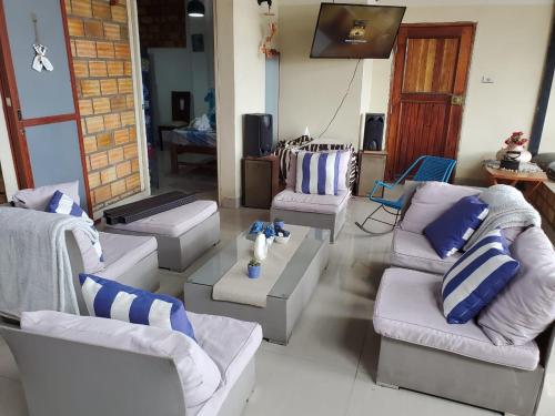 ein Wohnzimmer mit weißen Sofas und einem Fernseher in der Unterkunft REFUGIO ROSITA APARTAMENT in Tarapoto