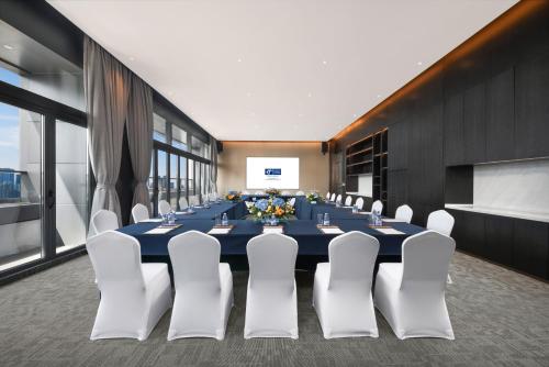 a conference room with a long table and white chairs at Holiday Inn Express Shenzhen Futian Center by IHG in Shenzhen