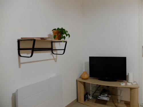 a tv sitting on a table in a living room at Gîte de Mam's - Voie verte in Bazeilles