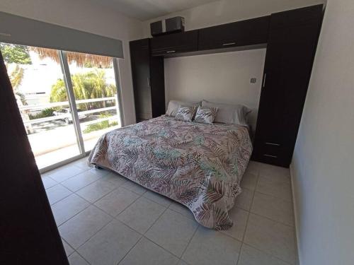 1 dormitorio con cama y ventana grande en Casa Kante, en Puerto Morelos