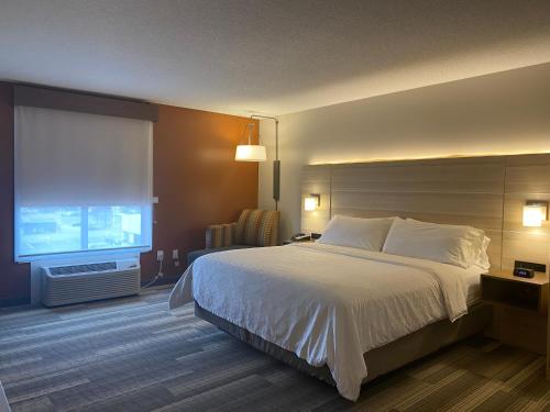 ein Hotelzimmer mit einem Bett und einem großen Fenster in der Unterkunft Holiday Inn Express & Suites La Porte, an IHG Hotel in LaPorte