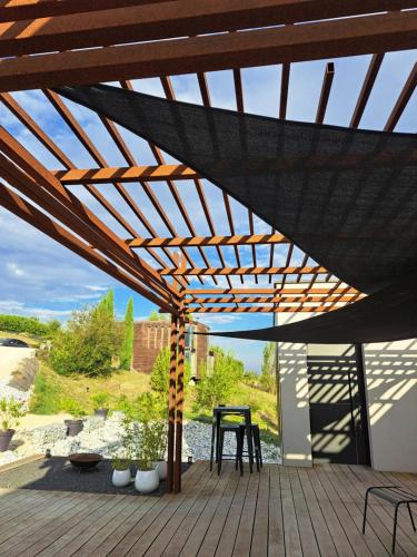 a wooden pergola with a table on a deck at Le 7 in Vieille-Toulouse