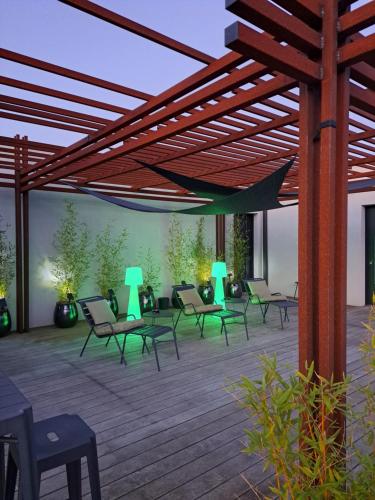 a patio with chairs and tables and a wooden deck at Le 7 in Vieille-Toulouse