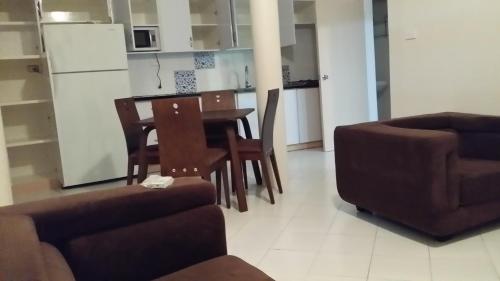 a living room with a table and chairs and a kitchen at Prestige Apartments - Solomon Islands in Honiara