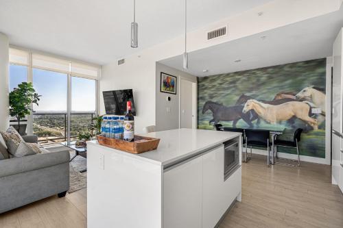 a kitchen and living room with a table and a couch at 35th FL w the BEST Views of the Stampede & Saddledome! FREE Banff Pass, Wine, Parking & Gym! in Calgary