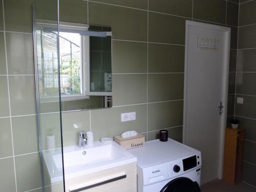 een badkamer met een wastafel en een spiegel bij Gîte de Mam's - Voie verte in Bazeilles