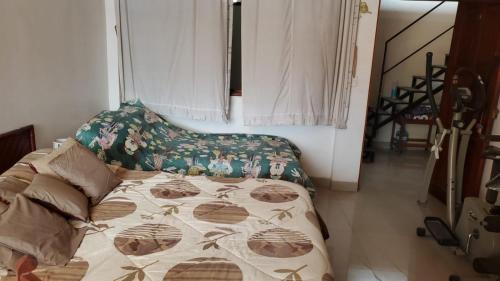 ein Schlafzimmer mit einem Bett mit einer Decke darauf in der Unterkunft REFUGIO ROSITA APARTAMENT in Tarapoto