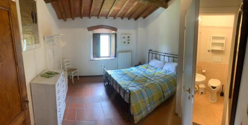 ein kleines Schlafzimmer mit einem Bett und einem Badezimmer in der Unterkunft Apartment on 2 floors for 2 to 4 guests in Donnini