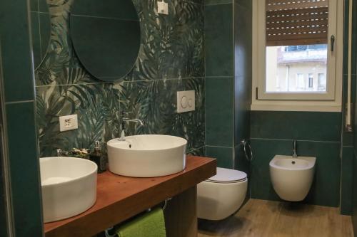 a bathroom with two sinks and a toilet at Accademia Apartment in Sassari