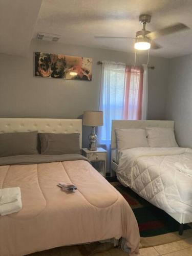 a bedroom with two beds and a lamp at Lovely indoor FPL w/ BBQ / FIREPIT near FSU & FAMU in Tallahassee