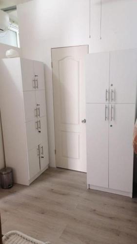 a room with white cabinets and white doors at Hostal Pampaloja Antof in Antofagasta