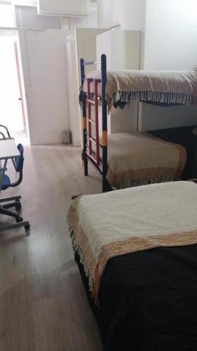 a room with three bunk beds and a desk at Hostal Pampaloja Antof in Antofagasta