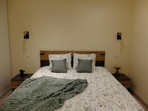 a bedroom with a bed with a blanket and pillows at Gîte de Mam's - Voie verte in Bazeilles