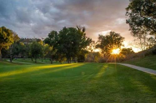 a view of a golf course with the sun setting at Residence Inn San Diego North/San Marcos in San Marcos