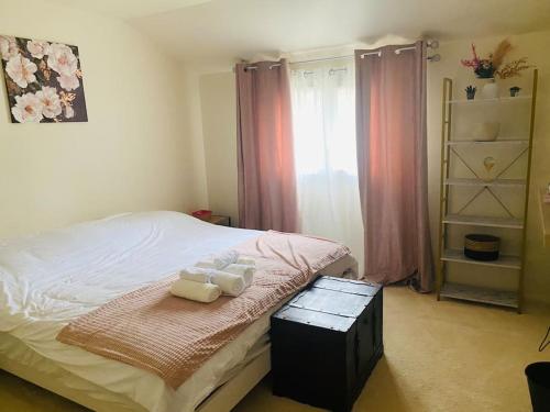 een slaapkamer met een bed met drie handdoeken erop bij Le Cocon - Petit déjeuner, Netflix, Jacuzzi* in Carrières-sous-Poissy