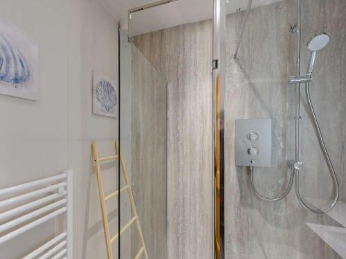 La salle de bains est pourvue d'une douche avec une porte en verre. dans l'établissement 1 Bed in Exmoor 81477, à Challacombe