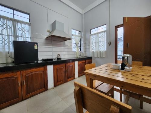 a large kitchen with a wooden table and a wooden table sidx sidx sidx at Cafe Sola bnb in Shillong